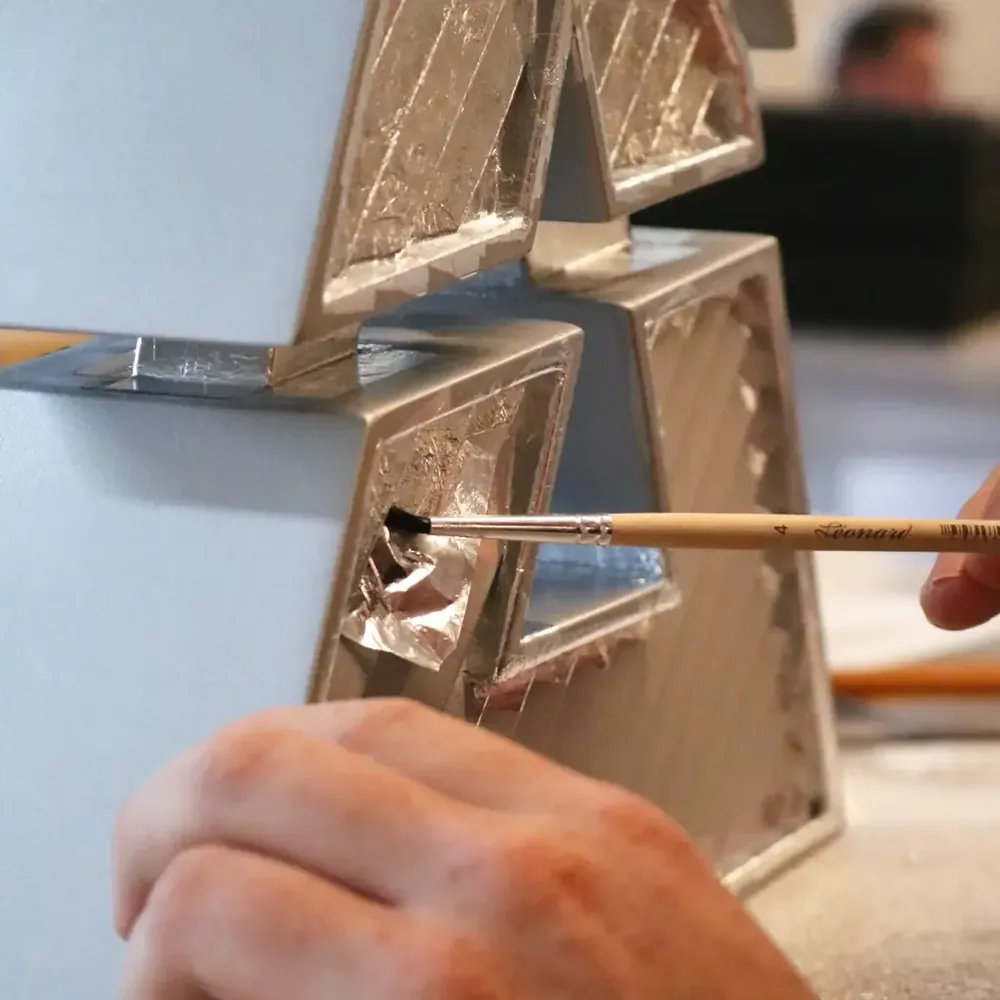 A trophy being finished by hand with a brush