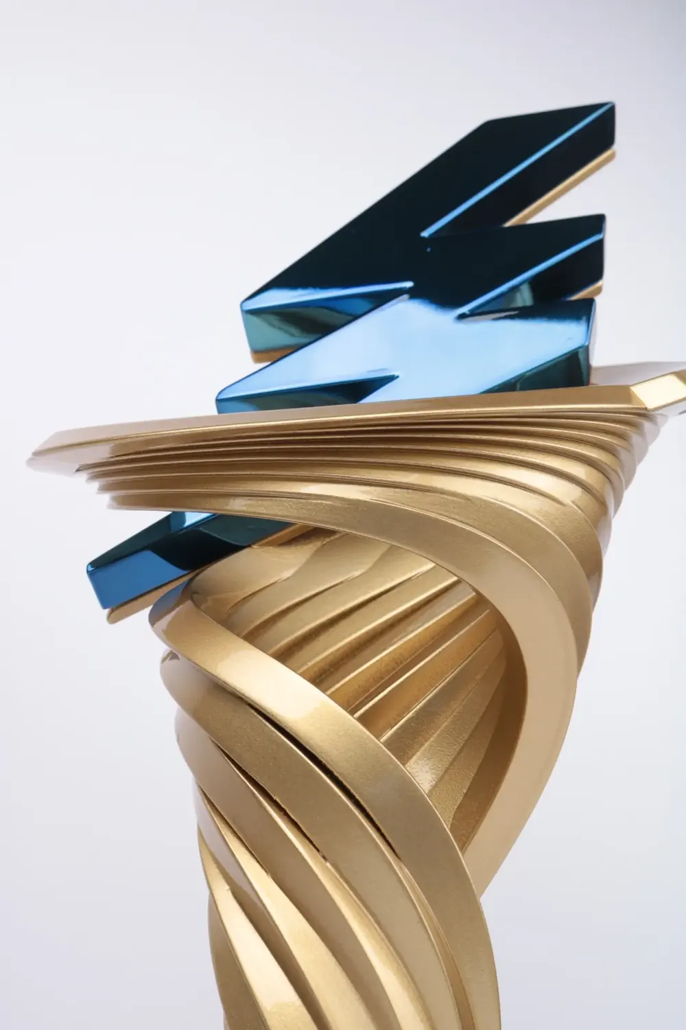 Gold spiral trophy opening around a blue metallic bolt